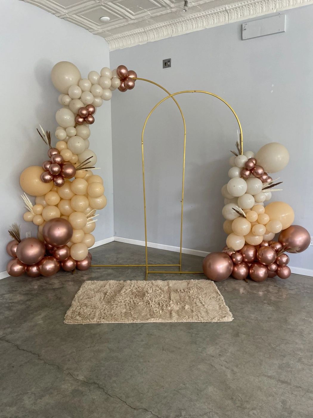 Cream and bronze balloons on twin gold arches